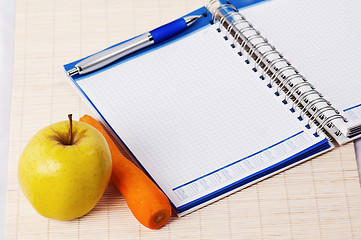 Image showing Open notebook, yellow apple and pencil 