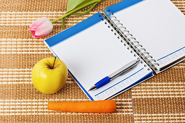 Image showing Open notebook, yellow apple and pencil 