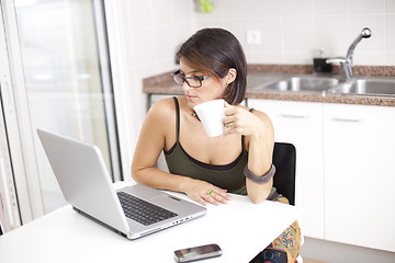 Image showing Modern woman reading e-mails at her breakfast