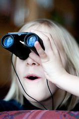 Image showing Young girl looking trought binoculars