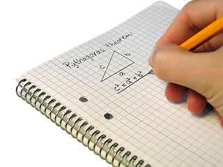 Image showing Student, writing down Pythagoras theorem in a notebook.