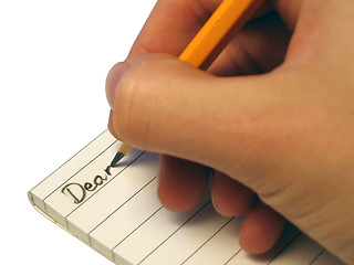 Image showing Someone writing 'Dear' in a notebook.