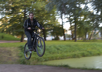 Image showing Mountain biker flying off in forest