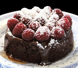 Image showing small chocolate cake with raspberries and caramel