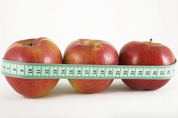 Image showing three red apple and green measurement tape