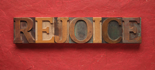 Image showing the word rejoice in old wood type on red