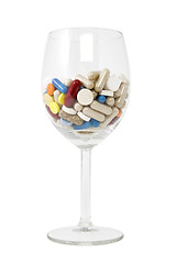 Image showing glass of multicolored tablets and capsules