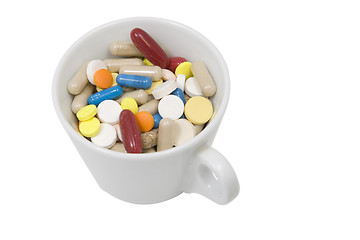 Image showing cup of multicolored tablets and capsules