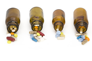 Image showing colored stream of pills coming from a pill bottles