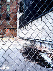 Image showing dirty NYC puddle behind fence