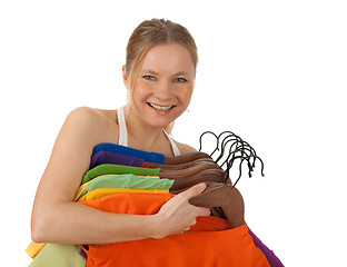 Image showing Charming young woman holding colourful clothes