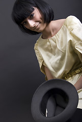 Image showing Young brunette holding a hat    