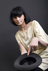 Image showing Young brunette holding a hat    