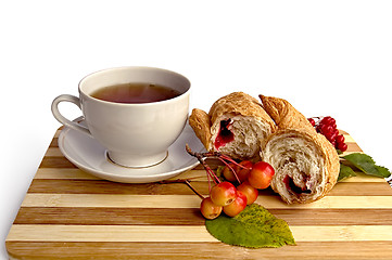 Image showing White cup and a croissant on the board