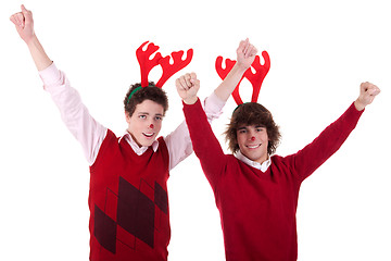 Image showing happy young men wearing reindeer horns, with arms raised, on white, studio shot