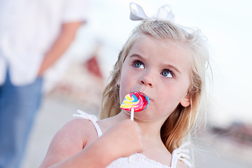 Image showing Adorable Little Girl Enjoying Her Lollipop Outside