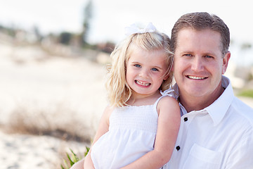 Image showing Cute Daughter Cuddles up with Her at the Beach