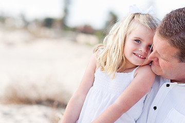 Image showing Cute Daughter Cuddles up with Her at the Beach