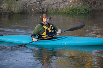 Image showing adult paddler in blue kayak