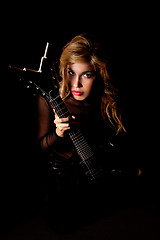 Image showing beautiful young woman sitting with a electric guitar