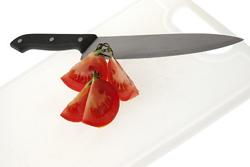 Image showing Cutting white plastic board with a knife and tomato