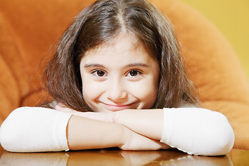 Image showing Little brunette sitting at table