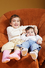 Image showing Funny sisters sitting in chair