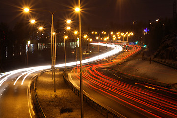 Image showing Car lights in the night on the town highway in winter
