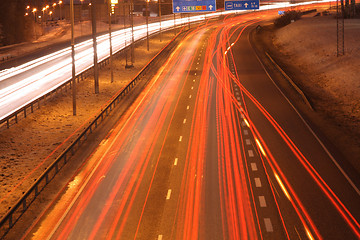 Image showing Car lights in the night on the town highway in winter lamplight.