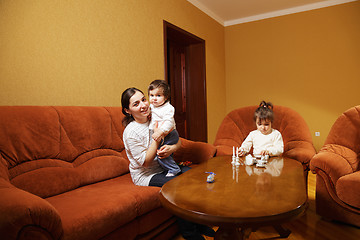 Image showing Smiling mother with daughters at home
