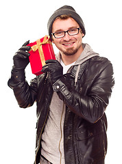 Image showing Warmly Dressed Young Man Holding Wrapped Gift To His Ear