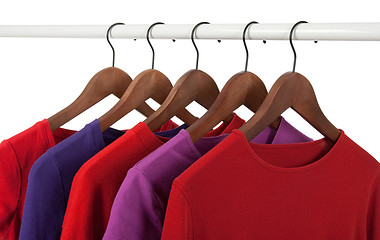 Image showing Red and purple casual shirts on hangers