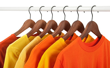 Image showing Yellow and orange casual shirts on hangers