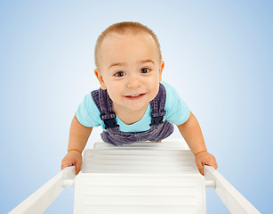 Image showing Little boy walking on ladder