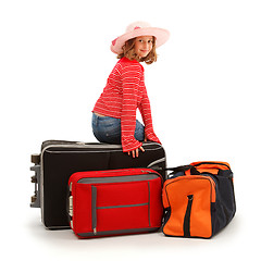 Image showing Girl sitting on luggage