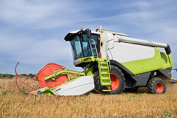 Image showing working harvesting combine in field