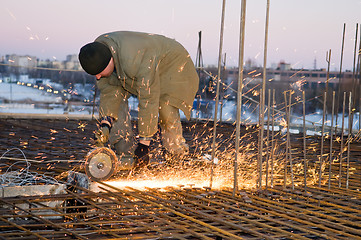 Image showing Builder with cutoff saw and sparkles