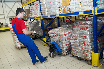 Image showing warehouse worker with forklift stacker