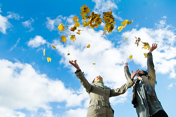 Image showing Two girls and Autumn leaves over blue sky