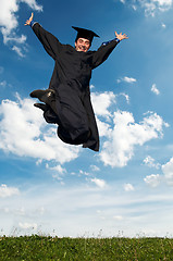 Image showing happy jumping graduate outdoors