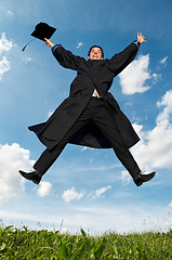 Image showing happy jumping graduate outdoors