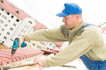 Image showing roofing works with screwdriver