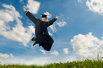 Image showing happy jumping graduate outdoors