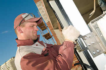 Image showing builder tightening a screws
