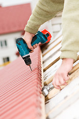 Image showing roofing works with screwdriver