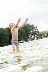 Image showing happy boy in water with splashes