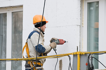 Image showing laborer in helmet at facade works