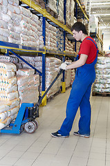 Image showing warehouse worker with forklift stacker