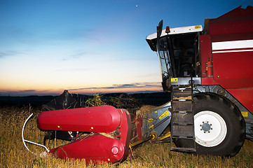 Image showing harvesting combine at sunset