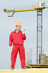 Image showing builder operating the tower crane